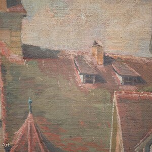 May include: A close-up of a painting depicting a cityscape with multiple buildings. The buildings have brown and red roofs and are painted in a realistic style. The sky is a light blue with a few clouds.