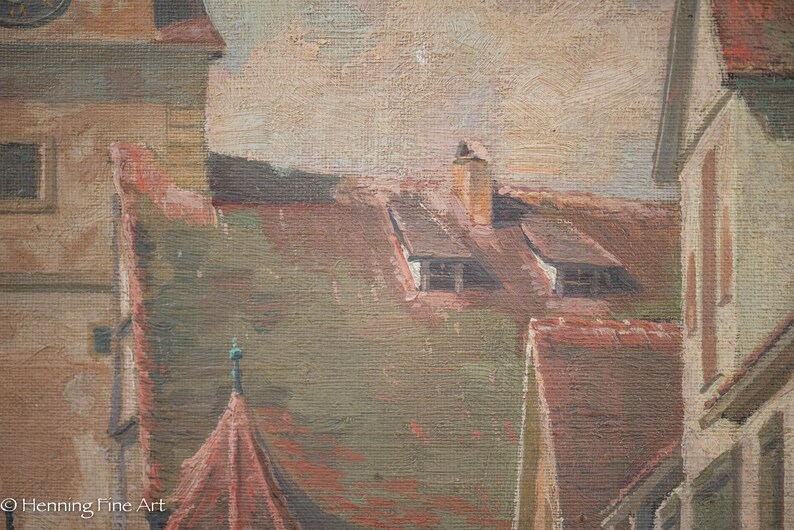 May include: A close-up of a painting depicting a cityscape with multiple buildings. The buildings have brown and red roofs and are painted in a realistic style. The sky is a light blue with a few clouds.