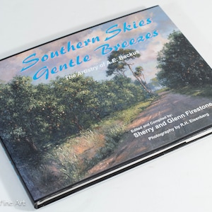 May include: Book cover featuring a painting of a country road lined with trees and a blue sky. The title is "Southern Skies Gentle Breezes" and the subtitle is "The Artistry of A.E. Backus".