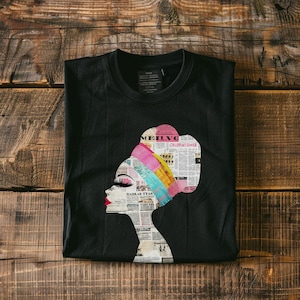 May include: Black t-shirt with a colorful graphic of a woman's face with a newspaper print head wrap. The graphic includes the text "MEILVG" and "CHLOROFORM INHALER".