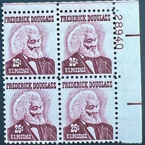 May include: A sheet of four 25-cent U.S. postage stamps featuring Frederick Douglass. The stamps are in a reddish-brown hue, each with a portrait of Douglass, the text "FREDERICK DOUGLASS" and "U.S. POSTAGE".