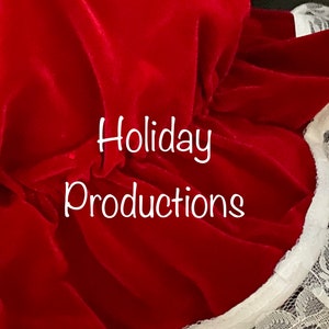 Pu&ograve; includere: Primo piano di un tessuto di velluto rosso con il testo "Holiday Productions" in bianco. Il tessuto ha un bordo a balze con finiture in pizzo bianco. L'immagine &egrave; ben illuminata, evidenziando la trama e il colore del materiale.