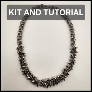 Peut inclure: Un collier en cotte de mailles couleur bronze à canon avec une série de pointes métalliques intégrées dans la partie inférieure des maillons. Le texte KIT AND TUTORIAL est affiché en lettres blanches sur un fond rectangulaire gris foncé.