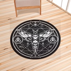 May include: Black and white round rug with a geometric design featuring a moth with skulls and the symbol of the Leviathan. The rug has a black background and white lines.