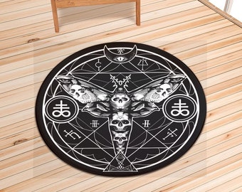 May include: Black and white round rug with a geometric design featuring a moth with skulls and the symbol of the Leviathan. The rug has a black background and white lines.