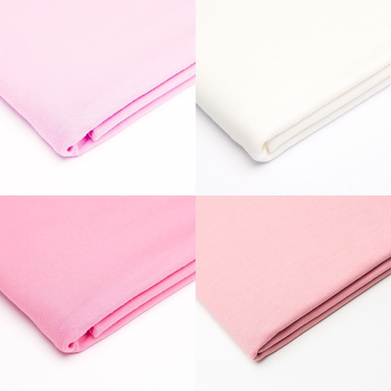 Puede incluir: Cuatro muestras de tela en diferentes colores: rosa, blanco y dos tonos de rosa claro. La tela est&aacute; doblada por la mitad y los bordes son visibles.