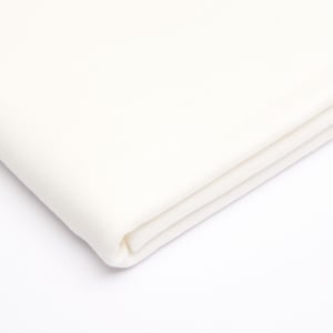 Puede incluir: Primer plano de una tela blanca doblada por la mitad. La tela es lisa y tiene un ligero brillo.