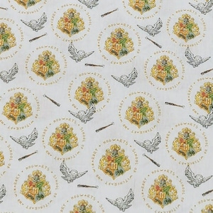 May include: White fabric with a repeating pattern of the Hogwarts crest, a white owl, and a wand. The crest is surrounded by the text "Hogwarts School of Witchcraft and Wizardry".