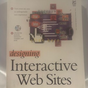 May include: A book titled "Designing Interactive Web Sites" with a white cover. The cover features a collage of text and graphics, including the words "true," "false," and "click here." A CD-ROM icon is also visible.