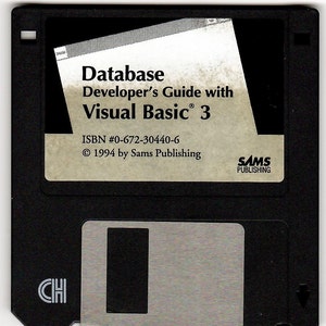 Op de afbeelding: Een zwarte 3,5-inch floppy disk met het label "Database Developer's Guide with Visual Basic&reg; 3", ISBN #0-672-30440-6 en copyright 1994 by Sams Publishing.