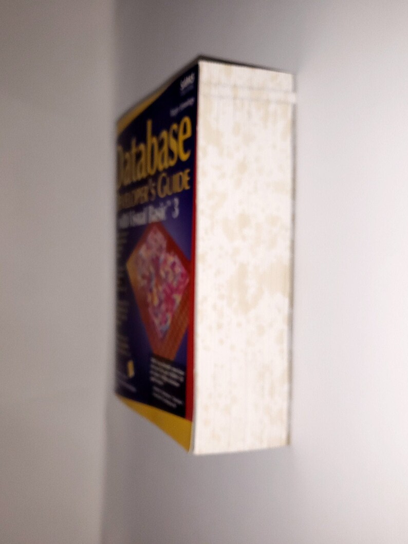 Op de afbeelding: Een blauw en geel boek met de titel "Database Developer's Guide with Visual Basic 3" op de omslag.