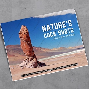 May include: A 2027 wall calendar titled Nature's Cock Shots featuring a large, vertical, reddish-brown rock formation in a desert landscape under a bright blue sky. The bottom text reads A COLLECTION OF PHALLIC FORMATIONS FOUND THROUGHOUT NATURE.