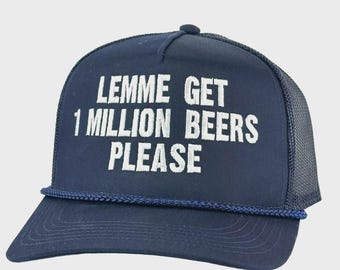 May include: Navy blue trucker hat with white embroidered text that reads "LEMME GET 1 MILLION BEERS PLEASE." The hat has a curved brim, a mesh back, and a dark blue rope detail along the front.