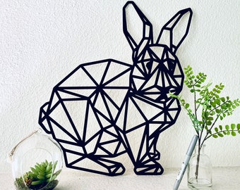 May include: Black geometric rabbit wall decor made of metal. The rabbit is in a sitting position with its ears up. The decor is a modern and minimalist design.
