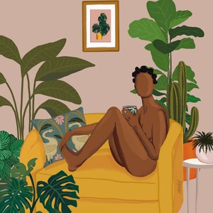 May include: A woman sits on a yellow couch in a room with plants. She is holding a cup and looking at the viewer. The couch has a patterned pillow and the room has a framed picture on the wall.