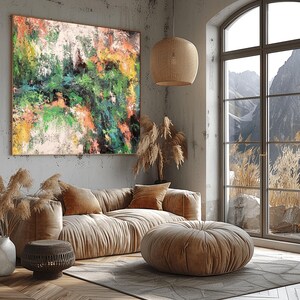 Puede incluir: Un gran cuadro rectangular sobre lienzo con una composición abstracta de pintura en capas en tonos vibrantes de verde, naranja, amarillo, negro y blanco, expuesto en un marco fino sobre una pared gris texturizada sobre un sofá beige.