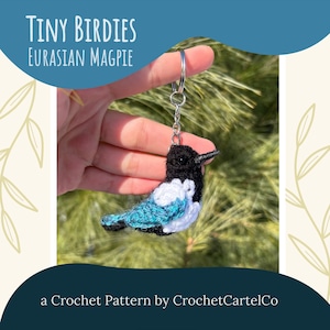 May include: Crochet pattern for a Eurasian Magpie keyring. The bird is black, white and teal blue. The pattern is called "Tiny Birdies".