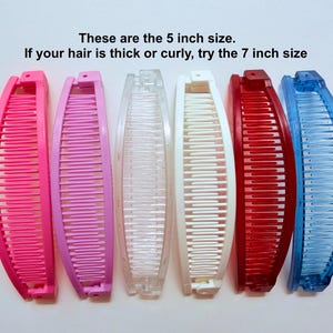 Puede incluir: Seis pinzas para el pelo en forma de pl&aacute;tano en rosa, morado, transparente, blanco, rojo y azul. El texto en la imagen dice: "Estas son las tallas de 5 pulgadas. Si tu cabello es grueso o rizado, prueba la talla de 7 pulgadas."