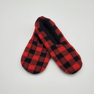 May include: A pair of red and black plaid slipper socks. The socks are made of a soft, comfortable material and have a fuzzy lining.