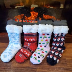 May include: Four pairs of cosy Christmas-themed slipper socks with fluffy white cuffs. The socks feature different patterns, including snowflakes, reindeer, penguins, and Santa Claus.