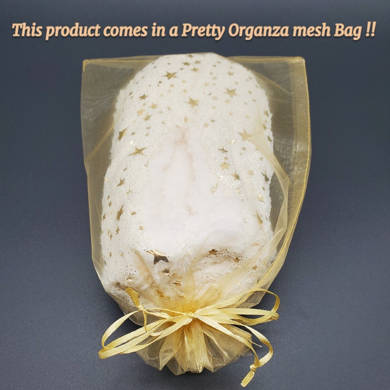 May include: A white, fluffy product is encased in a gold organza mesh bag. The bag is tied with a gold ribbon. The product is covered in gold star-shaped glitter. Text on the image reads: "This product comes in a Pretty Organza mesh Bag !!"