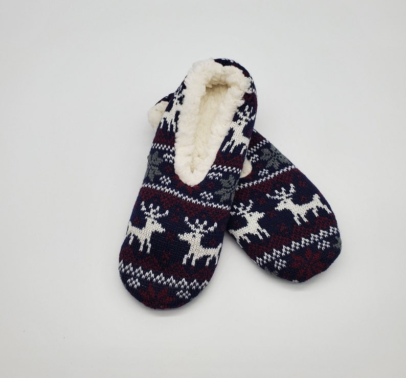 May include: Pair of blue, red, and white slipper socks with a reindeer pattern. The socks are lined with white faux fur.
