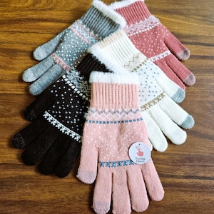 May include: A collection of colorful knit gloves with a fair isle pattern. The gloves are in shades of pink, white, gray, and black, with a faux fur trim. One glove has a tag that says "Texting Gloves".