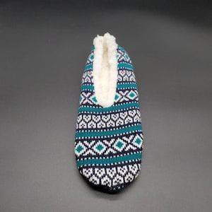 May include: A pair of blue, white, and green patterned slipper socks with a white fleece lining.