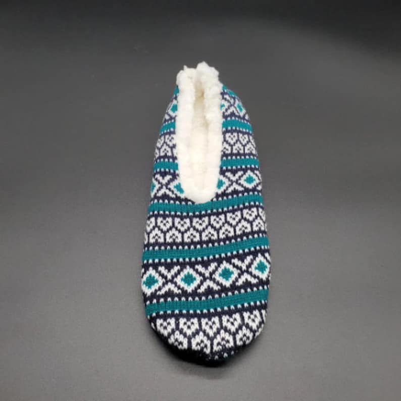May include: A pair of blue, white, and green patterned slipper socks with a white fleece lining.