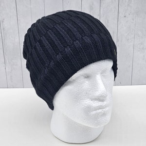 May include: A black knitted beanie with a ribbed texture.