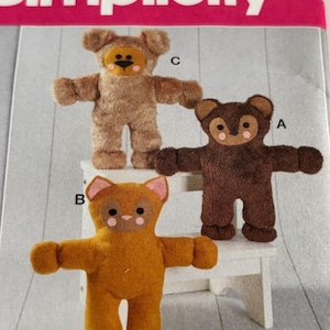 May include: Three plush teddy bears in various shades of brown and tan, each with a unique facial design. The bears have outstretched arms and are standing on a white surface. The word "Simplicity" is printed at the top.