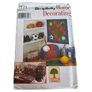 Może przedstawiać: Wzór szycia Simplicity Home Decorating numer 7771. Wzór zawiera instrukcje do wykonania różnych elementów dekoracyjnych do domu, w tym pufy, otomany do przechowywania, kołdry i torby. Wzór ma motyw sportowy z różnymi piłkami i sprzętem sportowym.