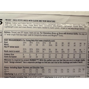 May include: A sewing pattern envelope back featuring Misses' and Miss Petite dress variations. It lists fabric requirements, notions including a 20-inch zipper, and a detailed body measurement chart for sizes 4 through 22 in inches.