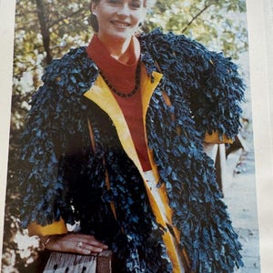 May include: A blue jacket with a unique fringed design. The jacket has yellow trim and is worn over a red top. The image also includes the text "Ladies Blue Jacket".
