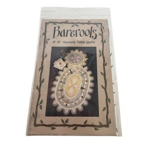 Puede incluir: Un paquete que contiene un patrón de edredón titulado "Bareroots #81 Heavenly Table Quilts". El patrón presenta una ilustración detallada de un edredón de mesa con diseños florales y geométricos, en tonos beige, amarillo y azul.