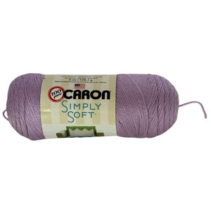 Pode incluir: Meada de fio Caron Simply Soft em um tom suave de lavanda. O rótulo indica 170,1 g e 288 m. O fio é 100% acrílico, ideal para tricô e crochê. O rótulo também indica 6 oz.