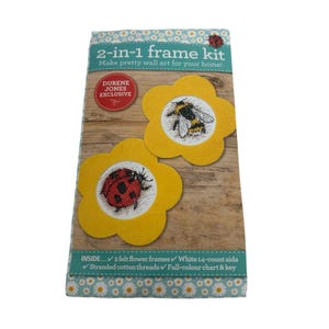 May include: A 2-in-1 frame kit for wall art. The kit includes two felt flower frames, white 14-count aida, stranded cotton threads, and a full-colour chart. The frames feature a ladybug and a bumblebee design. The packaging has the text "2-in-1 frame kit".