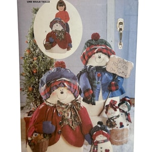 Puede incluir: Un patrón de costura Butterick con diseños de muñecos de nieve. El patrón incluye instrucciones para crear muñecos de nieve con sombreros, bufandas y abrigos. La imagen muestra varios muñecos de nieve terminados, algunos sosteniendo cestas y letreros. El texto dice "Happy Holidays From Our Family!"
