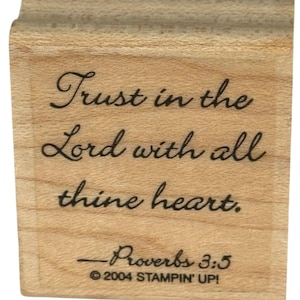 May include: A wooden stamp with the inscription "Trust in the Lord with all thine heart." The text is in a cursive font. Below the quote is "Proverbs 3:5" and the copyright information for Stampin' Up!
