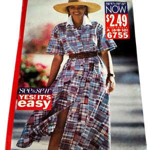 May include: A vintage sewing pattern cover featuring a woman wearing a plaid dress with a straw hat and a brown belt. The dress has a white collar and button-down front. The cover includes text that reads "See & Sew" and "Yes! It's Easy."