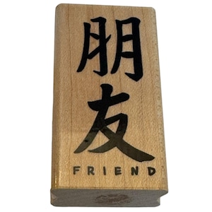 May include: A rectangular wooden stamp with the word "FRIEND" in English and Chinese characters. The stamp has a light brown color with black ink. The stamp is a useful tool for crafts and stationery.