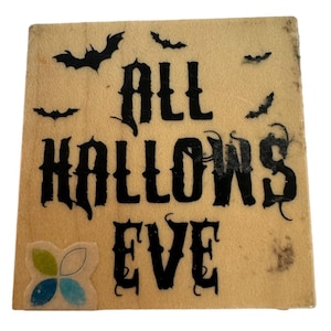 May include: A wooden sign with the text "ALL HALLOWS EVE" in black lettering. The sign is decorated with black bats.