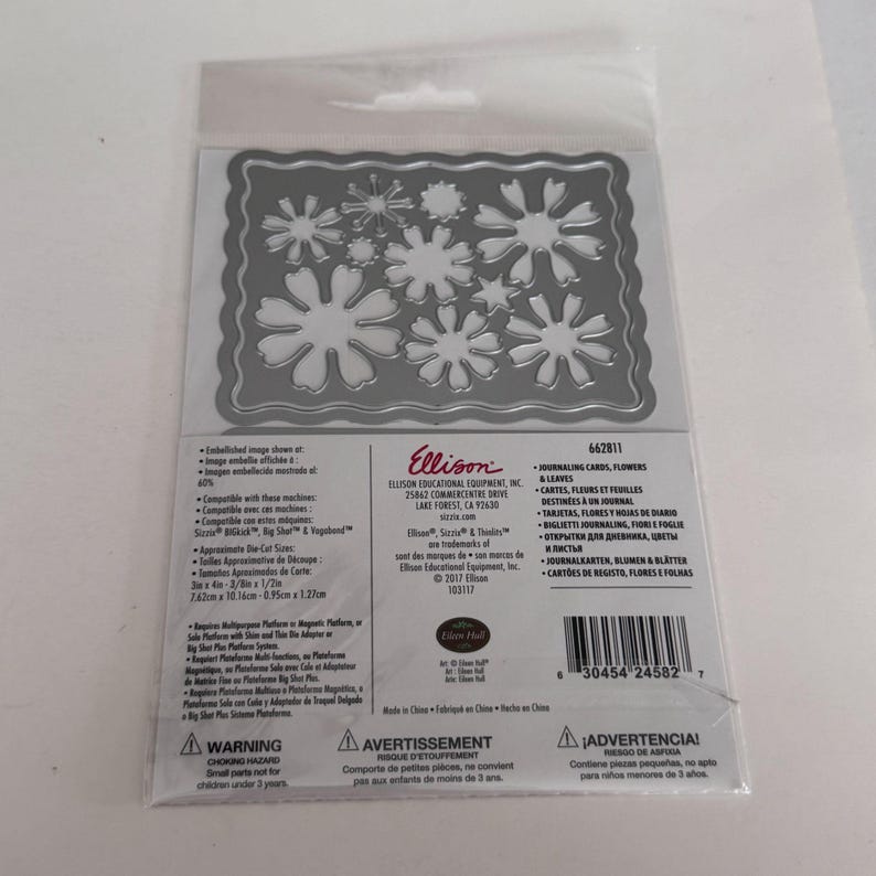 Op de afbeelding: Een zilverkleurige metalen snijmal met diverse bloem- en bladvormen binnen een geschulpte rechthoekige rand, verpakt in een doorzichtige plastic hoes met gedrukte productinformatie, waaronder de merknaam Ellison en het nummer 662811.