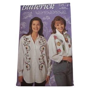 May include: A Butterick 6871 sewing pattern envelope featuring a purple background with white floral line art. The front displays two white long-sleeve button-down shirts, one with vertical floral embroidery and the other with various colorful patches.