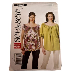 May include: See & Sew pattern B5480 for a peasant-style blouse with a gathered neckline and short sleeves. The envelope displays two variations: one with a multi-colored paisley print and another in solid lime green with a tie-front detail.