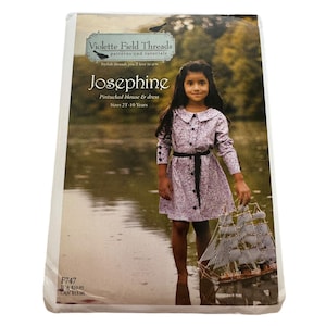 May include: A sewing pattern for a girl's dress and blouse called "Josephine" by Violette Field Threads. The pattern is for sizes 2T to 10 years. The image shows a young girl wearing the dress and blouse, standing in a lake with a toy boat.
