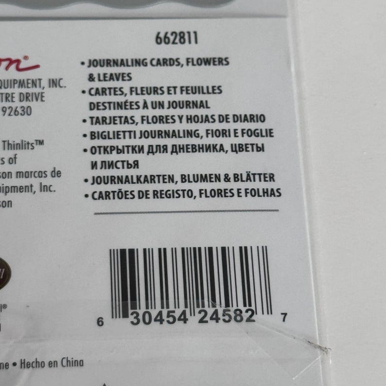 Op de afbeelding: Een productverpakkingslabel met de tekst 662811 en Journaling Cards, Flowers & Leaves. Het label bevat een streepjescode met het nummer 630454245827 en vermeldt de productnaam in meerdere talen, waaronder Frans, Spaans en Duits.