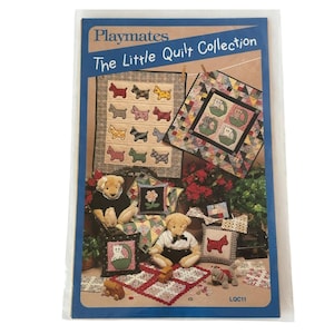 Op de afbeelding: Een Playmates "The Little Quilt Collection" patroonboek. De omslag toont afbeeldingen van kleine quilts met honden- en kattenontwerpen, teddyberen en decoratieve kussens. Het kleurenpalet omvat rood, geel, groen en blauw.