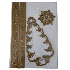 May include: A set of gold-colored metal cutting dies for crafting, featuring two long border strips with scalloped edges, a large stylized Christmas tree shape with intricate cutouts, and a single six-pointed snowflake design on a white backing.