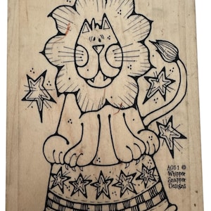 May include: A wooden stamp with a cartoon lion design, complete with a floral mane and tail, and star accents. The lion sits on a patterned base. The stamp includes the text "A051 © Whipper Snapper Designs."